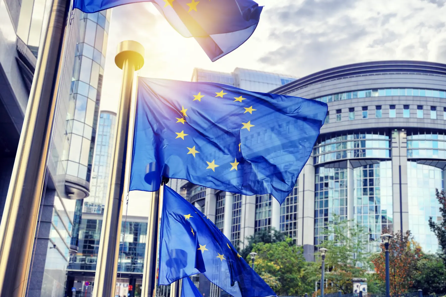 European Union flags waving in front of the Berlaymont building in Brussels