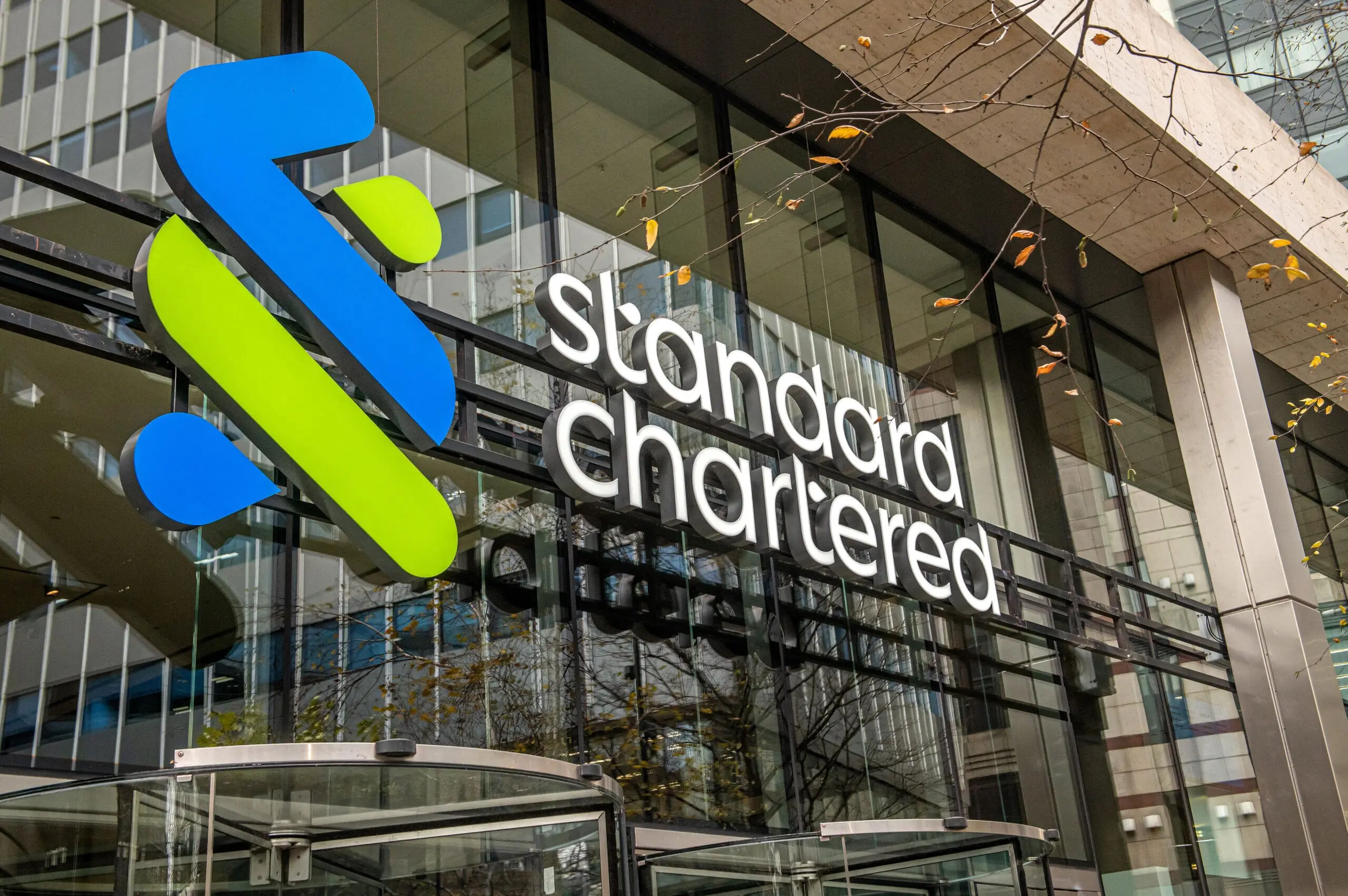 Standard Chartered logo displayed on the London headquarters building entrance.